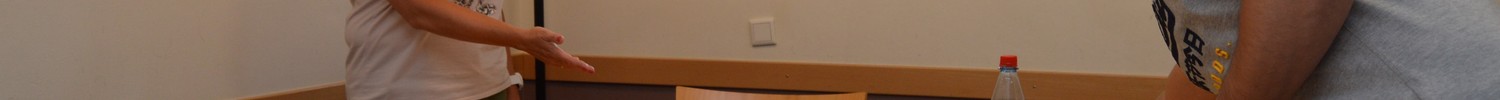 Eine Mitarbeiterin aus dem Pflege- und Erziehungsdienst und ein Patient decken gemeinsam einen Tisch ein für das Abendessen auf der Wohngruppe.