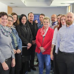 Eine Gruppe Frauen und Männer lächelt in die Kamera